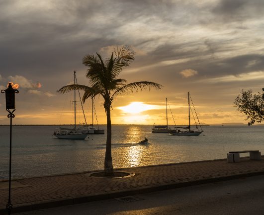 Sunset in the ocean with sailing ships in the water on Bonaire