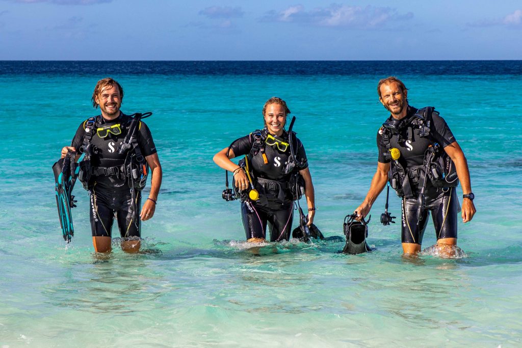 three divers exiting the Caribbean sea