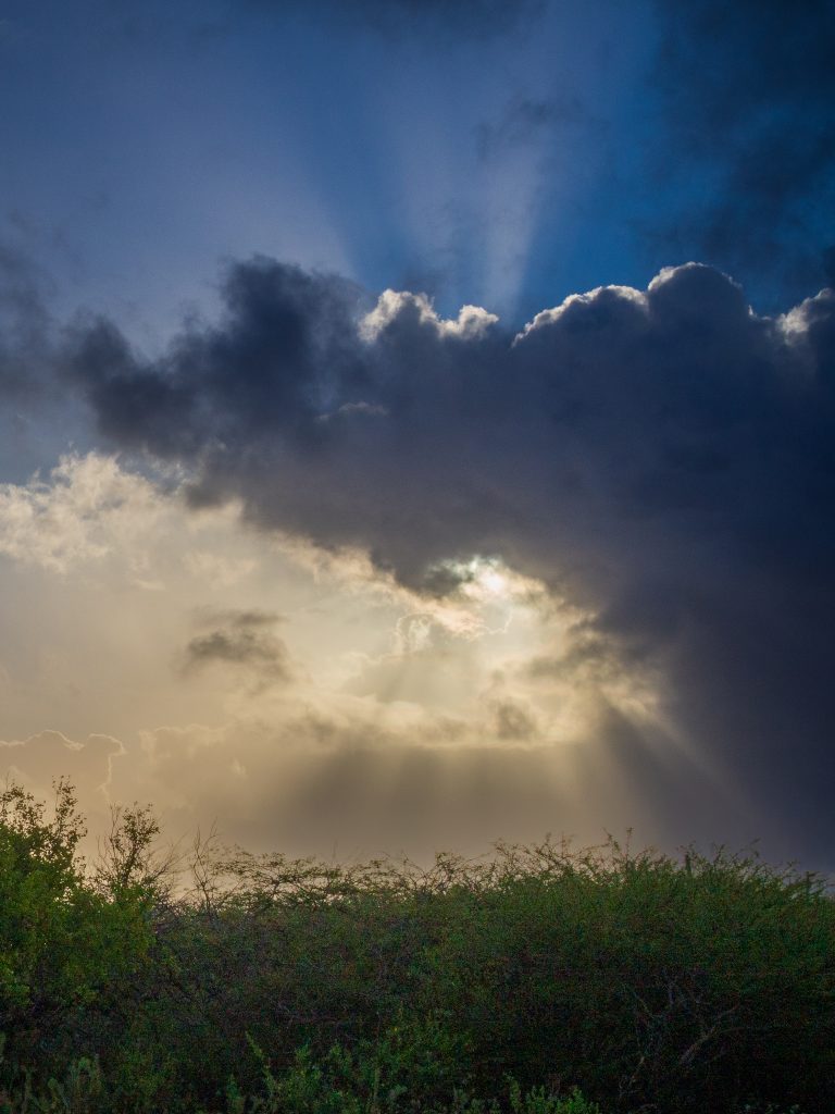 standing picture of sun coming thru the clouds on Bonaire