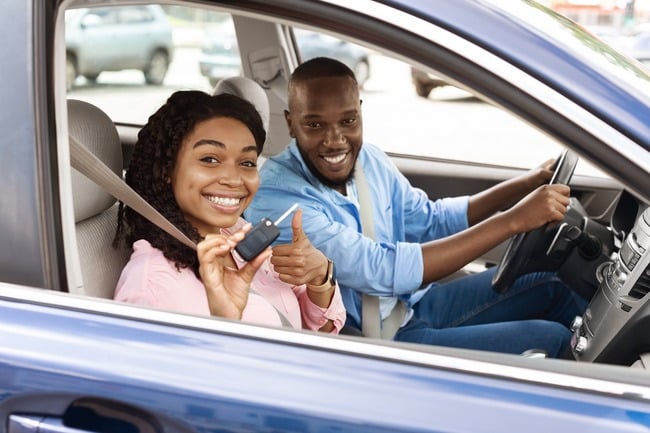 Couple receiving the key to their rental car