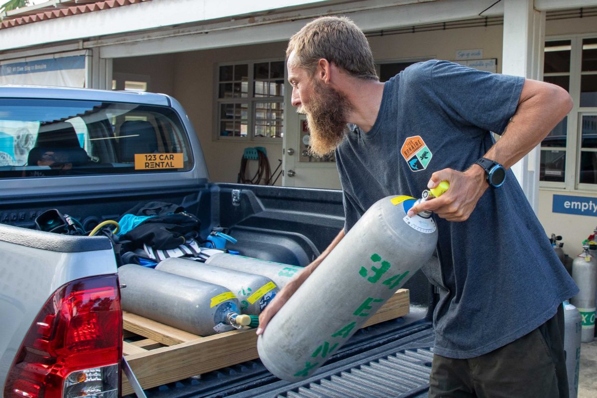 diver putting tanks in the back of a pickup truck
